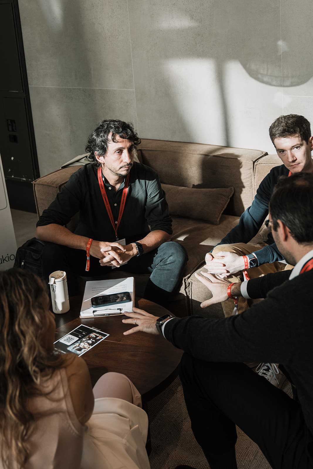 A small group in a focused deal conversation on a lounge sofa