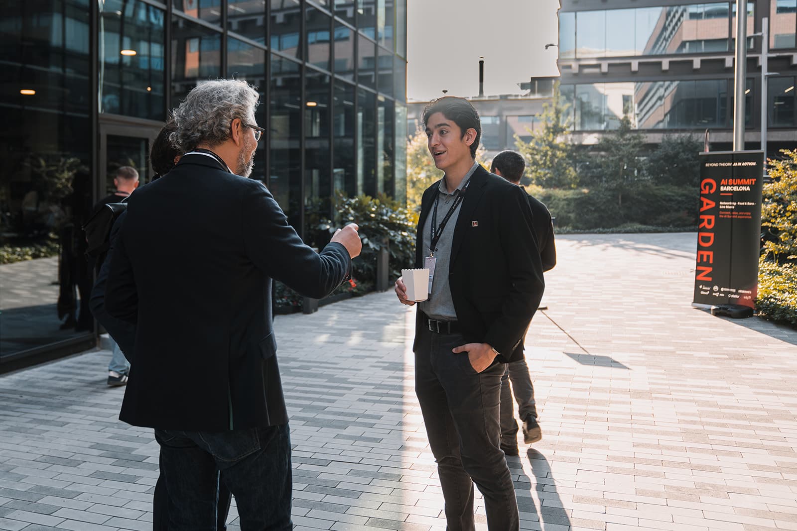 Two attendees in conversation in the summit's open-air garden